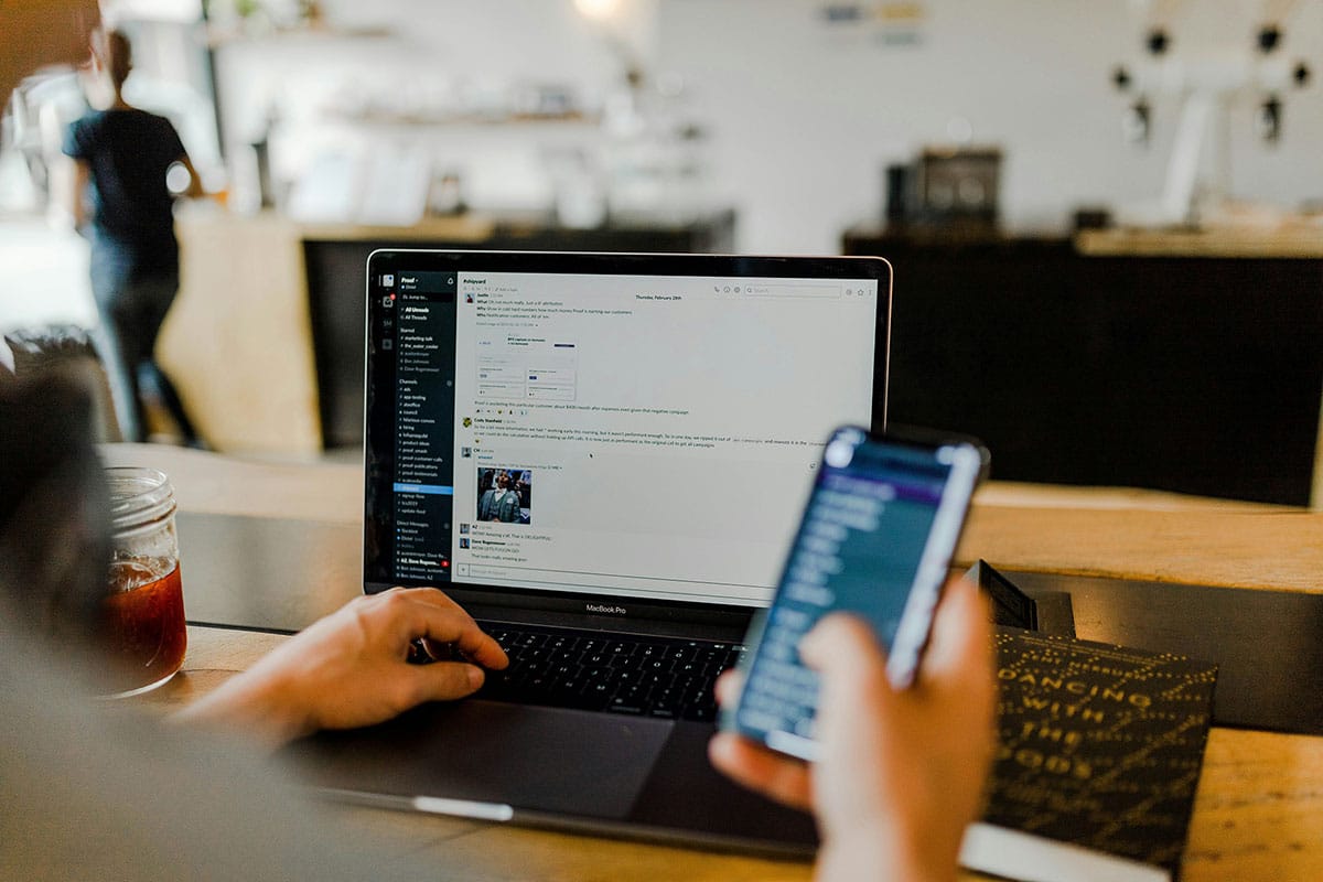 A person using the laptop and mobile phone